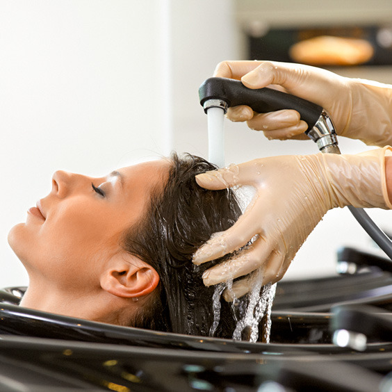 Einer Frau werden beim Friseur die Haare gewaschen